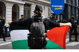 متظاهرة ترفع علم فلسطين في مواجهة قوات مكافحة الشغب الفرنسية أمام السفارة الإسرائيلية بباريس، احتجاجًا على اعتراض "أسطول الصمود" المتجه إلى غزة وللمطالبة بإنهاء الحصار وإدانة العدوان المستمر على القطاع.